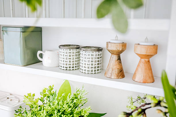 istock Decorative home accessories arranged on a shelf with plants and candles in a bright room 2207984308