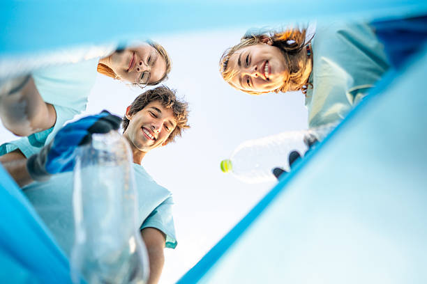 istock Young volunteers putting plastic bottles in a trash bag 2207984532