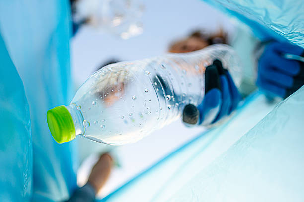 istock Young volunteers putting plastic bottles in a trash bag 2207984561