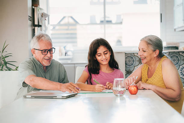 istock granddaughter doing homework with  grandparents 2207985666