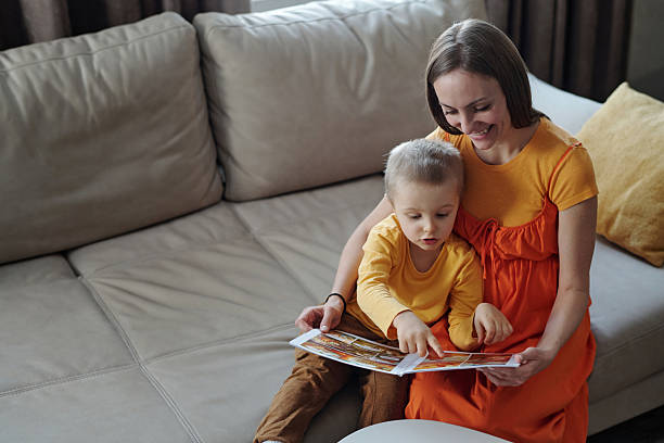 istock Happy Mother Reading Book with Son 2207986123