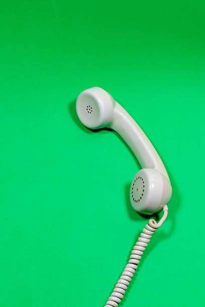 istock Gray handset of old telephone on a green surface 2207987330