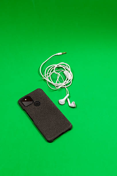 istock Composition of smartphone and earphones placed on green table 2207987573