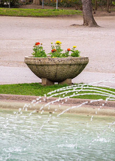istock Colorful Flower Planter by Fountain in Park 2207990418