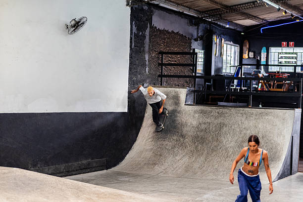 istock Young man skating down ramp at indoor park 2207991020