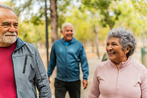 istock Senior friends talking and walking on the public park 2207991024