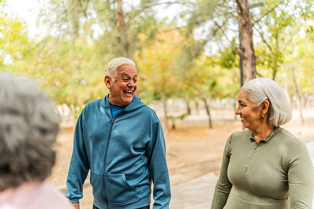 istock Senior friends talking and walking on the public park 2207991034