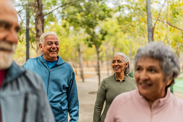 istock Senior friends talking and walking on the public park 2207991035