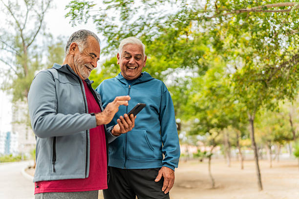 istock Senior friends men talking and using mobile phone outdoors 2207991039