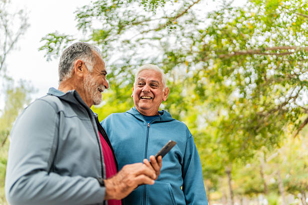 istock Senior friends men talking and using mobile phone outdoors 2207991044