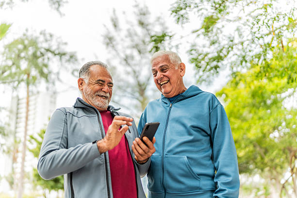 istock Senior friends men talking and using mobile phone outdoors 2207991052