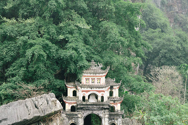 istock The structure of a building is visible, with lush trees behind it Ninh Binh, Vietnam 2207993477