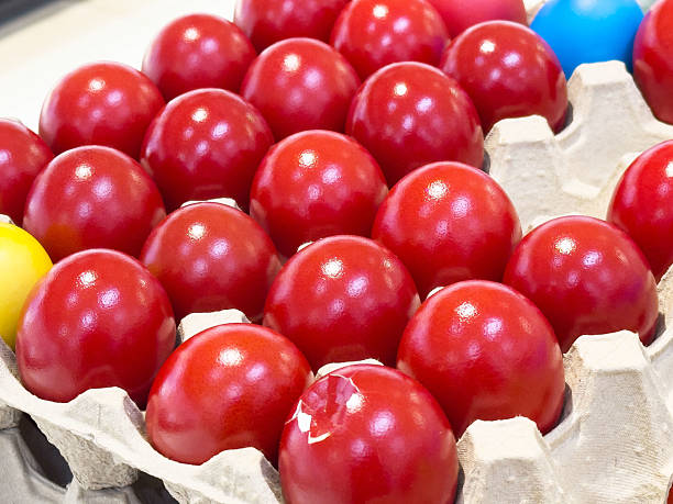 istock Vibrant red and colorful painted easter eggs in carton 2207993619