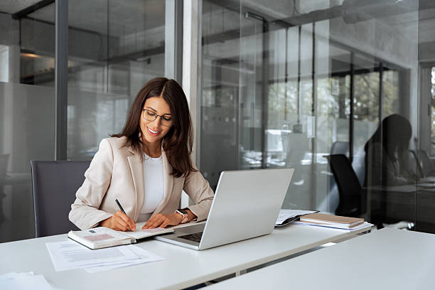 istock Latin hispanic woman using laptop computer for business studying it having videocall with online virtual webinar training meeting, writing notes. Focused businesswoman working in office. Copy space 2208002581