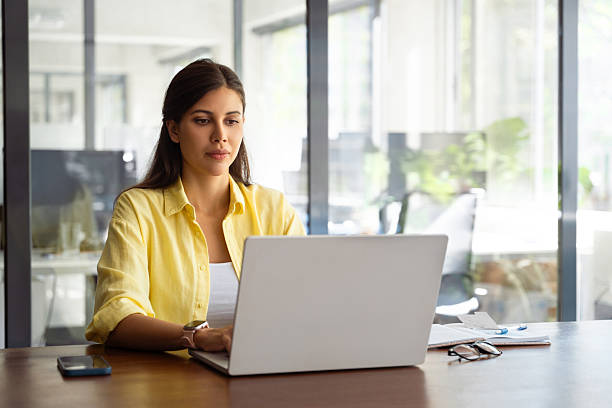 istock Female freelance entrepreneur working on online technological project on computer pc at company workplace. Focused young latin business woman, it specialist using laptop at work in office. Copy space 2208002621