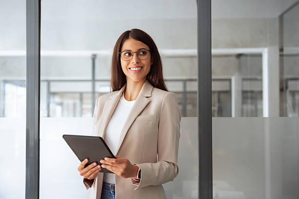 istock Businesswoman professional boss holding digital tablet pc device for work in office, looking dreaming at copy space. Young smiling latin hispanic woman using computer for business working application 2208002623