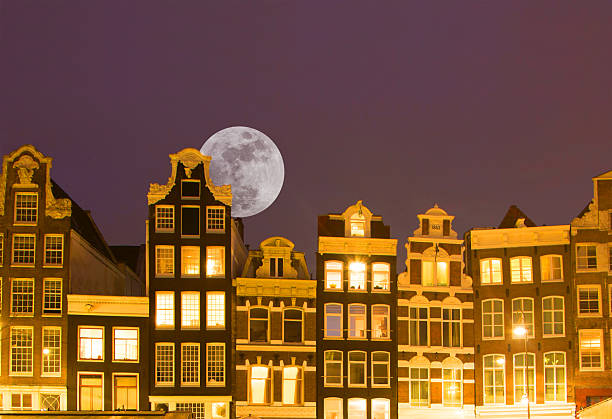 Netherlands Amsterdam, moonrise over dutch tall houses in central amsterdam