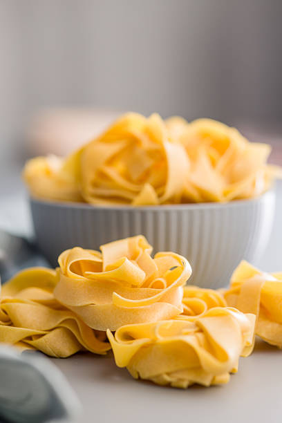 istock Italian pasta tagliatelle. Uncooked noodle pasta on gray background. 2208003263