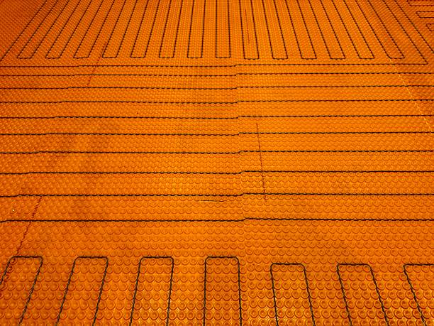 New heated flooring (wires and flooring material) fill up the frame of this closeup image taken during a home remodel.