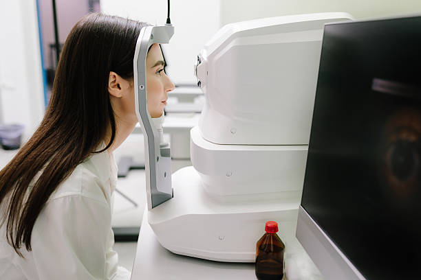 istock Examination of eyes of patient using optical coherence tomograph. Ophthalmologist is scanning cornea of girl patient. Optical coherence tomography OCT scan to create pictures of the back of eye. 2208005308