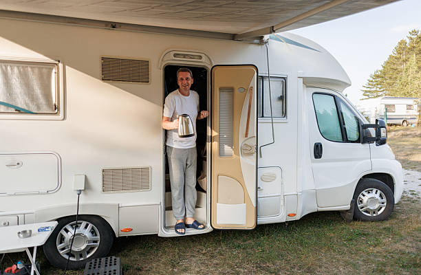 istock Happy Camper Standing at RV Door with Hot Water Kettle 2208005840