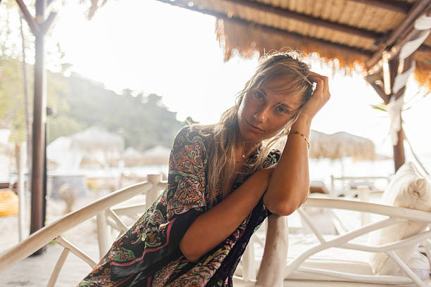 istock Beautiful woman relaxing at a beach bar 2208005891