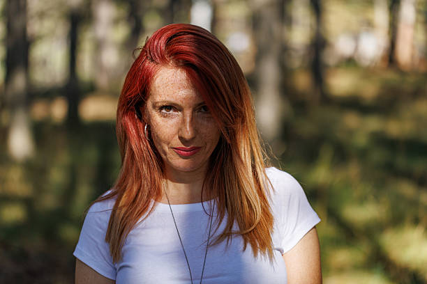 istock Woman with Long Red Hair Standing in Forest Sunlight 2208006622