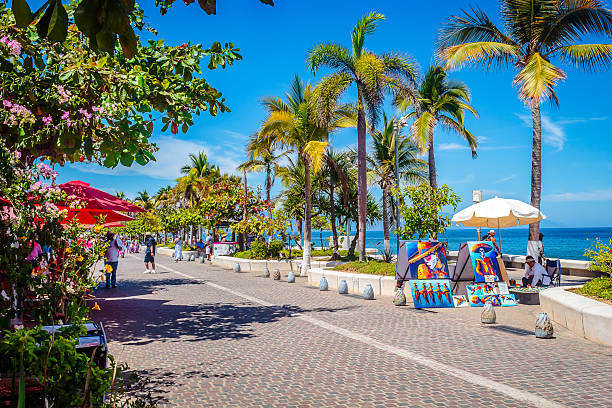 Tourists strolling on a sunny day on the Malecon in Puerto Vallarta, Jalisco Puerto Vallarta, Jalisco Mexico, April 29 2024 Tourists strolling on a sunny day on the Malecon in Puerto Vallarta, Jalisco floating dock stock pictures, royalty-free photos & images