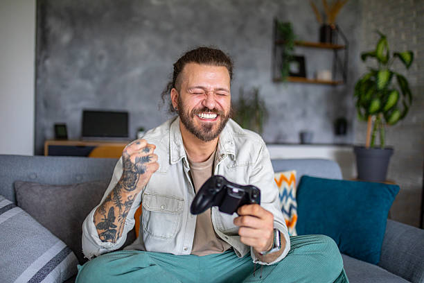 istock A man in a relaxing living room environment is focused playing a video game with a joystick 2208009176