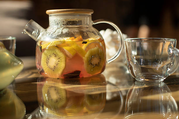 istock Teapot with tea on table. Summer fruit drink. Fruit tea in clear teapot. 2208009677