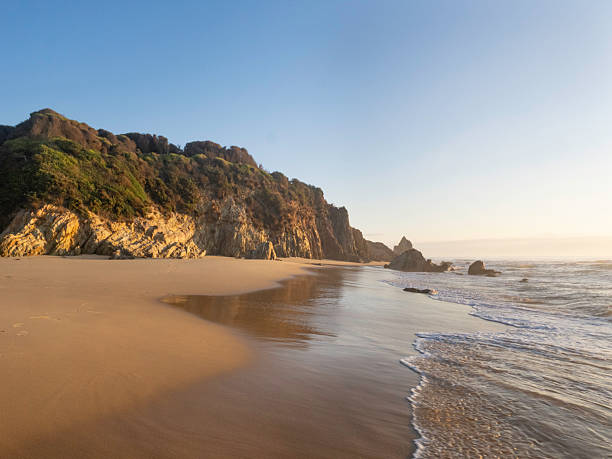 istock Sunrise light on rocks and sand at beach 2208010022