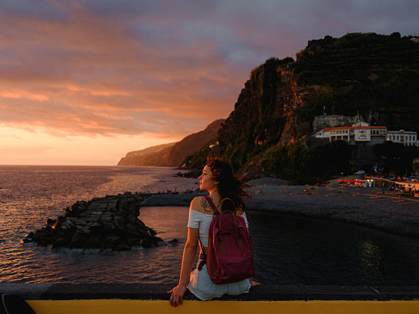 istock Woman looking at sunset over Atlantic ocean in Ponta do Sol, Madeira 2208011073