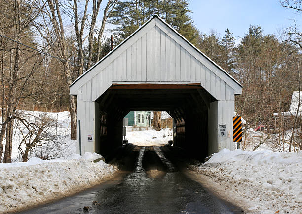 istock Looking Through a Covered Bridge in Winter Landscape With Snow and Clear Blue Sky 2208012536