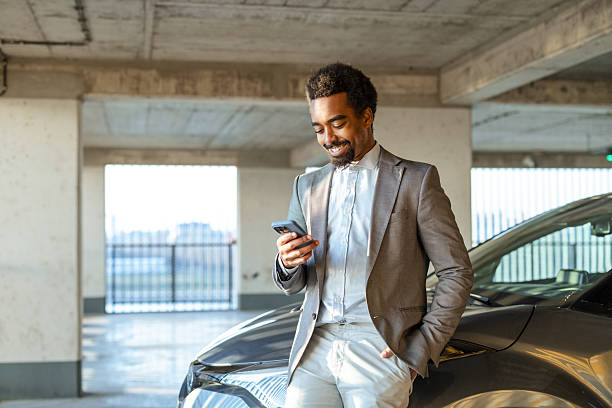 istock Confident businessman relaxing by his car in a parking garage 2208013532