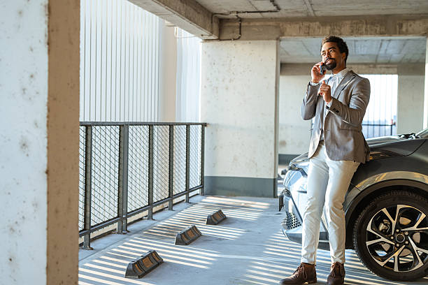 istock Professional man making a phone call in a modern parking area 2208013564