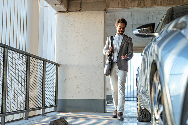 istock Businessman walking in a parking garage holding a key 2208014436