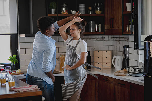 istock Joyful young couple dancing playfully in the kitchen, sharing laughter and happiness while preparing breakfast together in a bright, cozy home setting. 2208024376