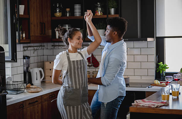 istock Joyful young couple dancing playfully in the kitchen, sharing laughter and happiness while preparing breakfast together in a bright, cozy home setting. 2208024382