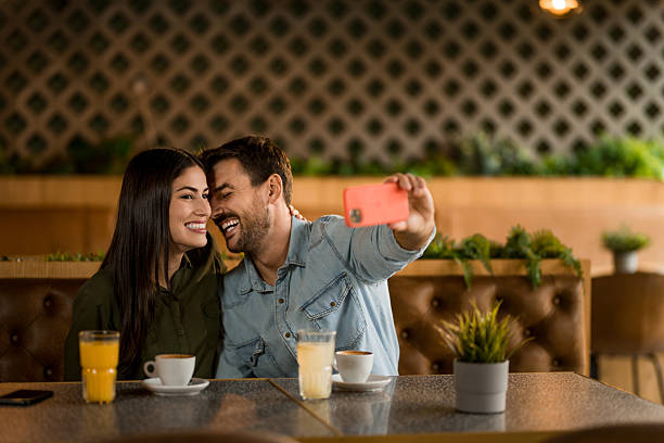 istock Happy couple taking a selfie with smart phone in cafe. 2208026292