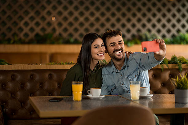 istock Happy couple taking a selfie with smart phone in cafe. 2208026344