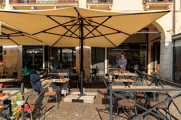 Sassari , Sardinia, Italy, May 27, 2024 - Tourists and locals sit in front of the Cafè Giordano / Lounge Bar, in the historic old town of Sassari, Sardinia.