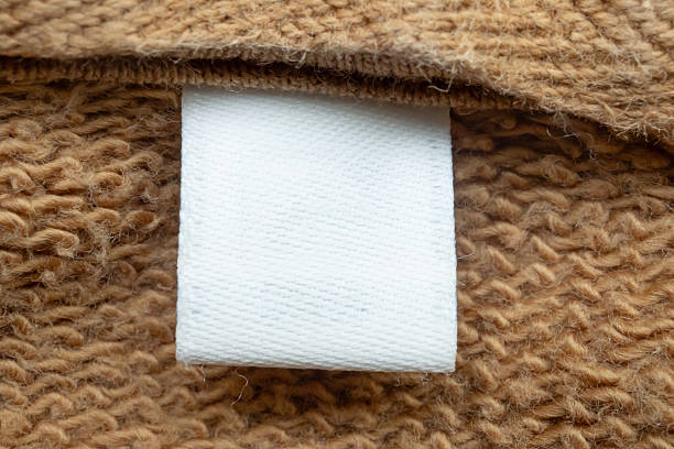 istock White blank laundry care clothes label on brown shirt fabric background 2208027504