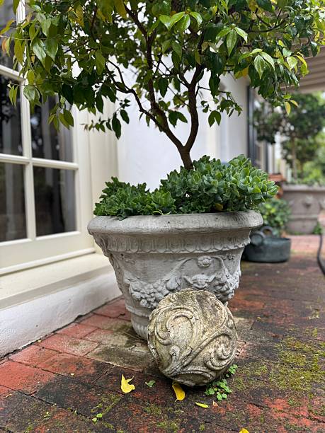 istock Ornate Garden Ball Sculpture with Surrounding Pots 2208030162