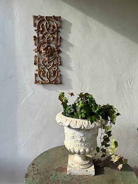 istock Old Style Pot with Plant and Metal Wall Sculpture 2208030333