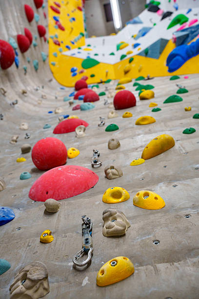 istock Artificial  indoor climbing wall with climbing routes. Colorful climbing holds, bolds and quickdraws on a textured wall 2208030939