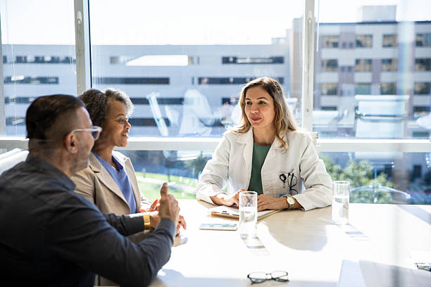 istock Doctor Consulting with Patients in a Bright Office 2208039875