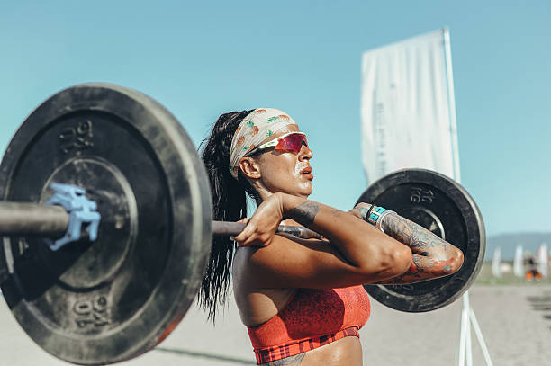 istock Female Athlete Lifting Weights Outdoors 2208040353