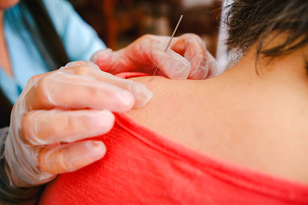 istock Dry needling needle stuck in an elderly patient's back, use of gloves for a physical rehabilitation procedure 2208043404