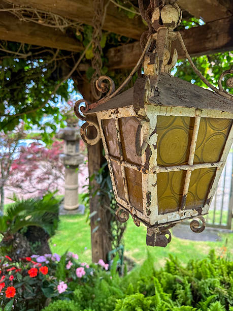 istock Rustic Hanging Lantern in Garden with Flowers and Greenery 2208045217