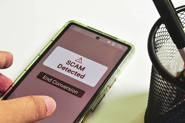 istock Scam alert on mobile screen. Close-up, woman hand, office desk background. 2208045367